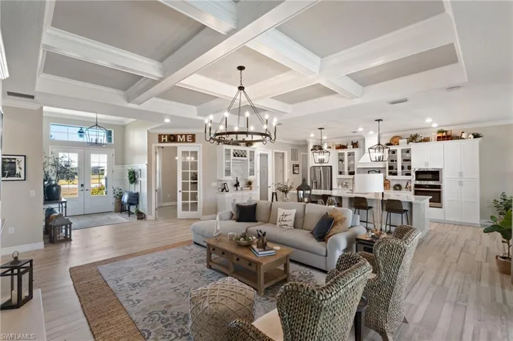 Living room featuring french doors, coffered ceiling, light hardwood / wood-style flooring, and beamed ceiling