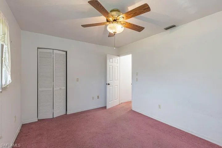 Unfurnished bedroom with carpet, ceiling fan, and a closet