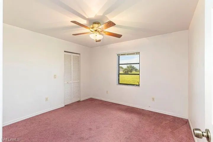 Empty room with carpet floors and a ceiling fan