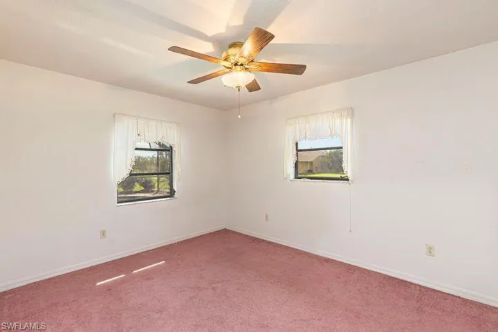 Carpeted empty room with baseboards and ceiling fan