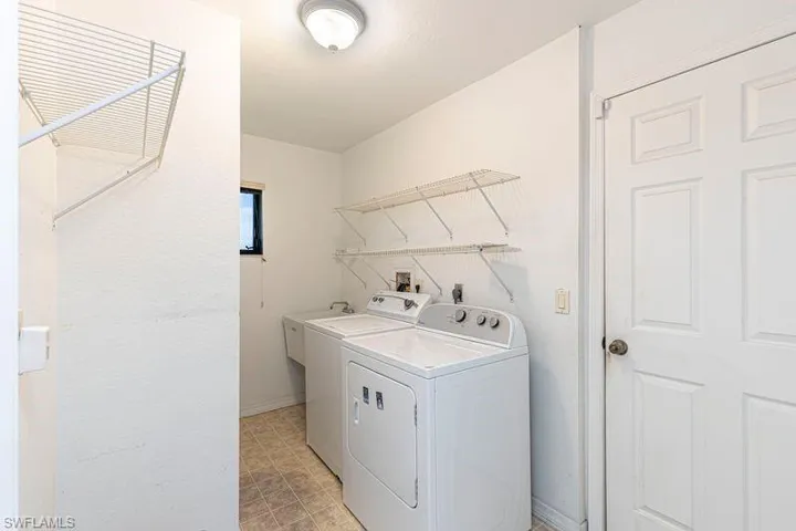 Laundry room with separate washer and dryer and baseboards