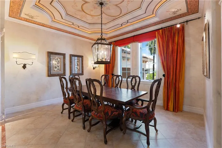 Dining area with an inviting chandelier, ornamental molding, and a tray ceiling