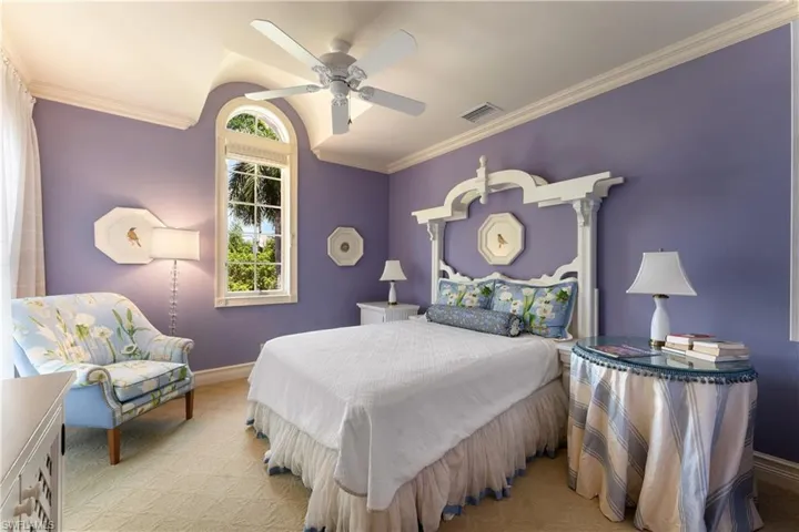 Carpeted bedroom with ornamental molding and ceiling fan