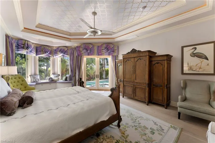 Bedroom featuring ceiling fan, access to outside, and a raised ceiling