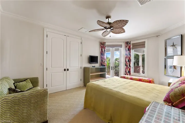 Bedroom featuring french doors, light carpet, ornamental molding, and ceiling fan