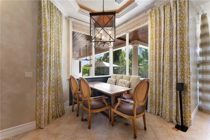 Dining room featuring crown molding, a tray ceiling, and a chandelier