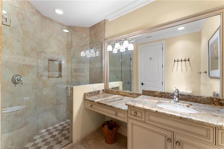 Bathroom featuring vanity, crown molding, tile patterned flooring, and an enclosed shower