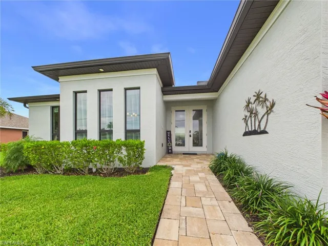 Contemporary stucco exterior with a flat roofline and dark brown gutters