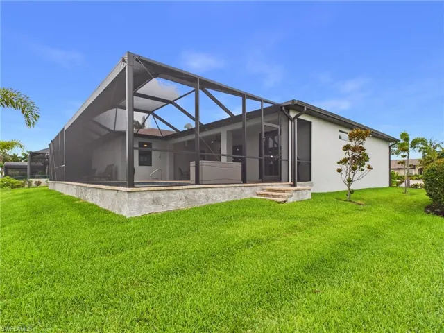 Expansive screened lanai featuring an in-ground pool, spa, and paver patio