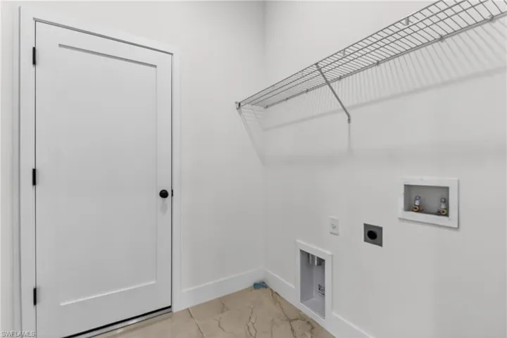 Laundry room featuring hookup for an electric dryer, light marble finish flooring, and washer hookup
