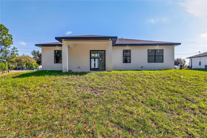 View of front facade with a front yard and stucco siding