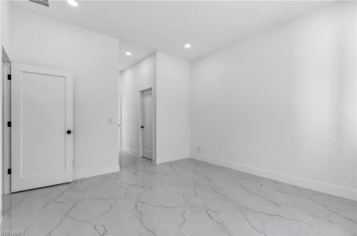 Unfurnished bedroom with light marble finish flooring and recessed lighting