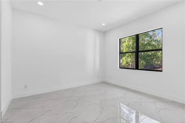 Unfurnished room featuring recessed lighting and light marble finish flooring