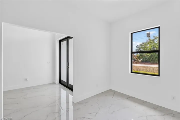 Unfurnished room featuring light marble finish floors and french doors