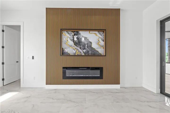 Detailed view of a glass covered fireplace and an accent wall