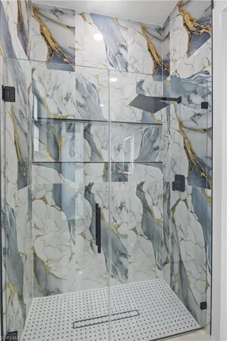 Bathroom featuring a marble finish shower