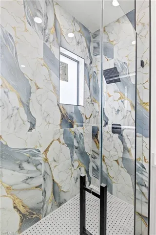 Full bathroom with a marble finish shower