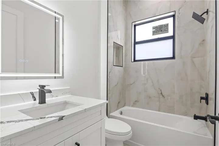 Bathroom with vanity and washtub / shower combination