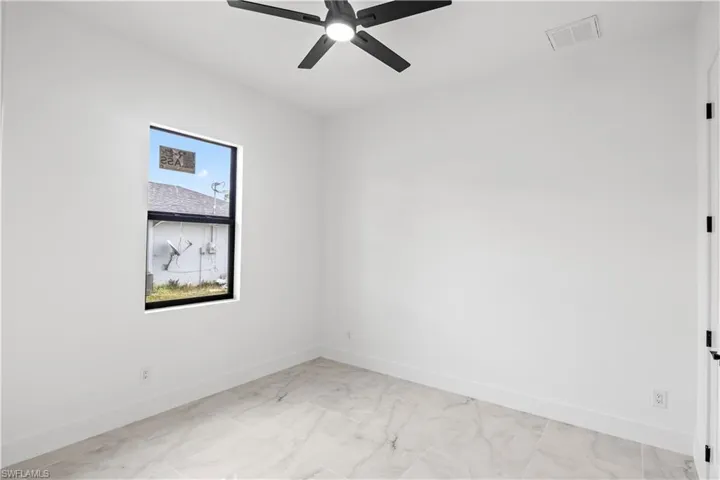 Spare room featuring a ceiling fan and light marble finish flooring