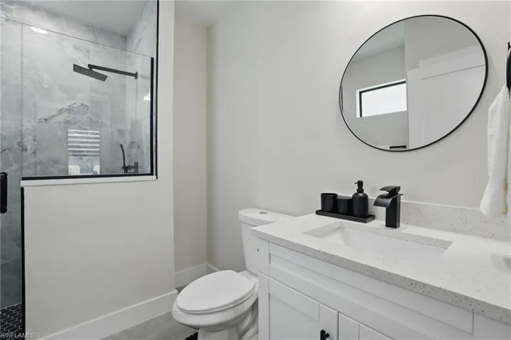 Full bath with toilet, a shower stall, and vanity