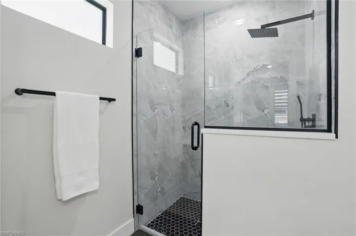 Bathroom with a marble finish shower