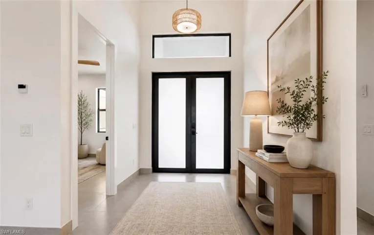 Entryway featuring a double-door entrance with frosted glass inserts, a transom window, and high ceilings