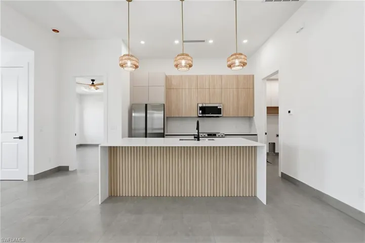 Modern kitchen island featuring a slatted wood-look base and a white countertop