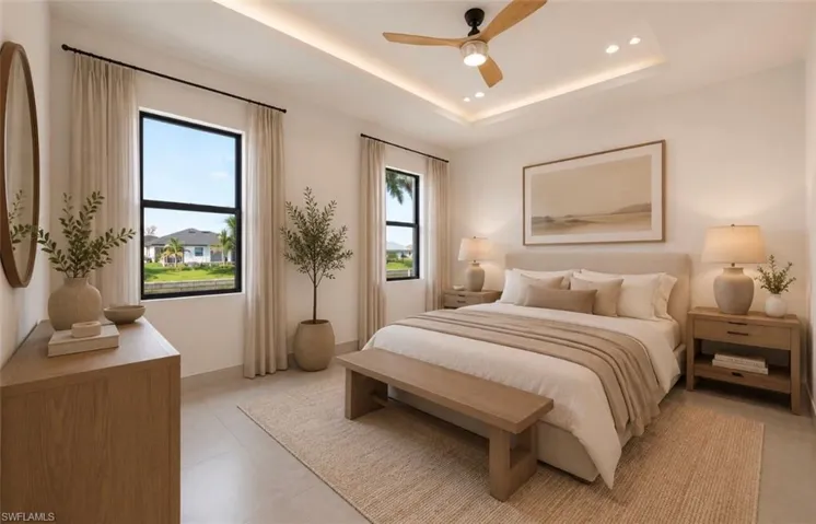 Spacious bedroom featuring multiple windows, a tray ceiling with recessed lighting, and a contemporary ceiling fan