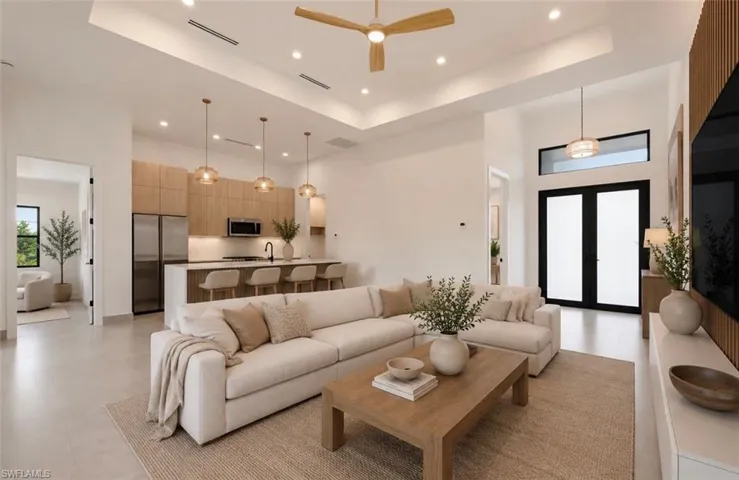 Open concept living area featuring high ceilings, recessed lighting, and large format tile flooring