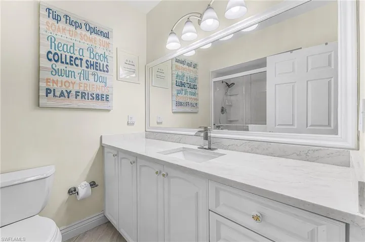 Master bathroom ensuite  has ample countertop space, a custom framed mirror, and updated fixtures.