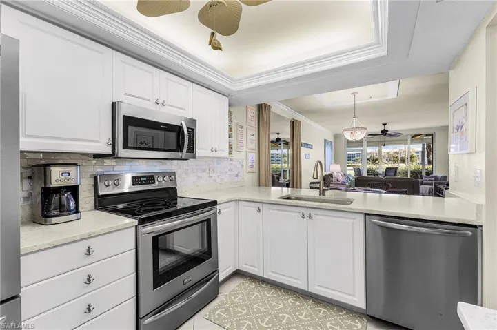 Can you see yourself in this beautifully remodeled kitchen w/newer appliances, decorative ceiling, lovely quartz countertops? The view out to the course is unobstructed. Extra cabinets were thoughtfully placed across from the refrigerator.