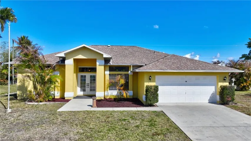 View of front of property with french doors, roof with shingles, a front yard, and a garage