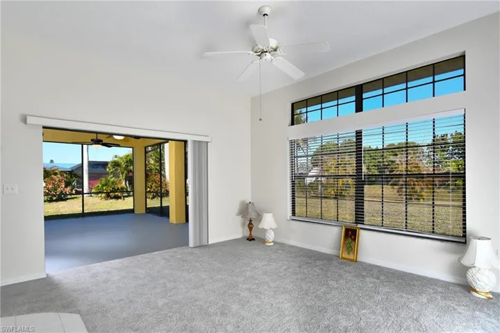 Carpeted spare room with a ceiling fan and baseboards