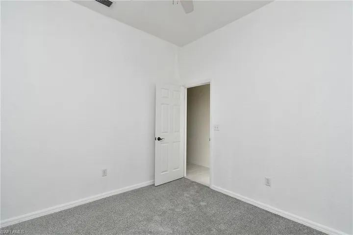 Empty room with carpet floors and a ceiling fan