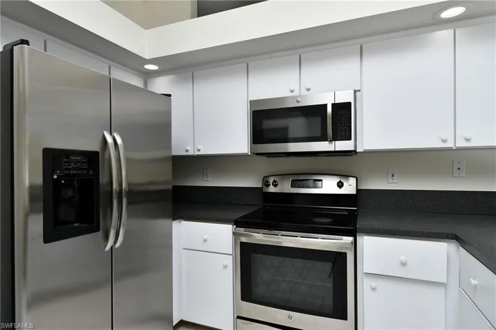 Kitchen with stainless steel appliances, white cabinetry, and recessed lighting