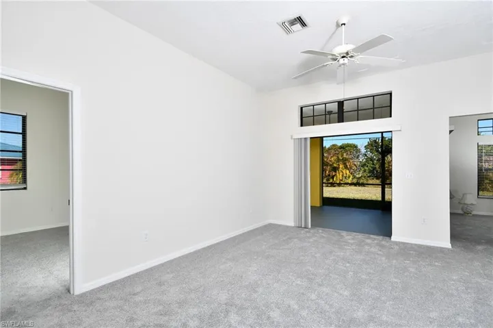 Unfurnished room with ceiling fan and light colored carpet