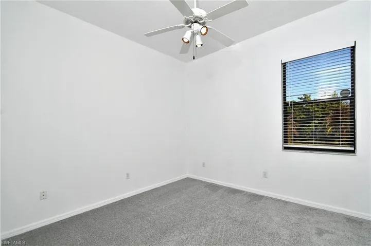 Spare room featuring carpet and ceiling fan
