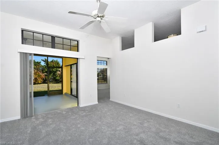 Spare room with a high ceiling, a ceiling fan, and carpet floors