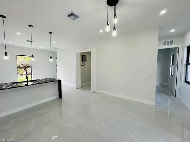 Unfurnished living room featuring recessed lighting and baseboards