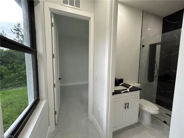 Full bath with a marble finish shower and vanity