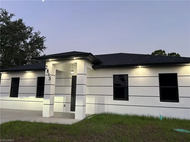 View of property exterior with roof with shingles and stucco siding