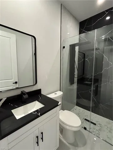 Full bath with vanity and a marble finish shower