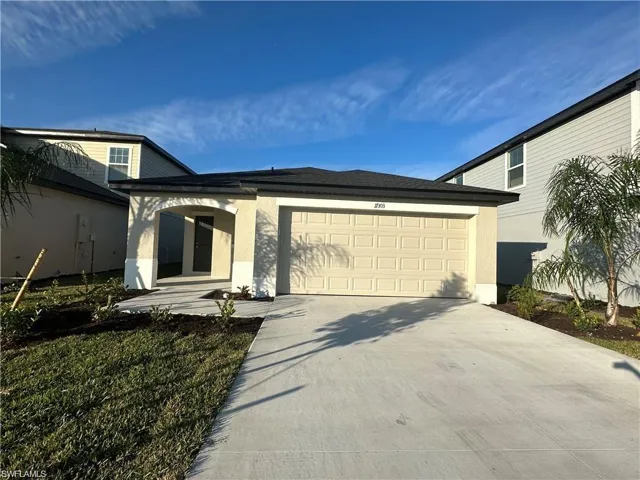 View of front of home with stucco siding, driveway, and an attached garage
