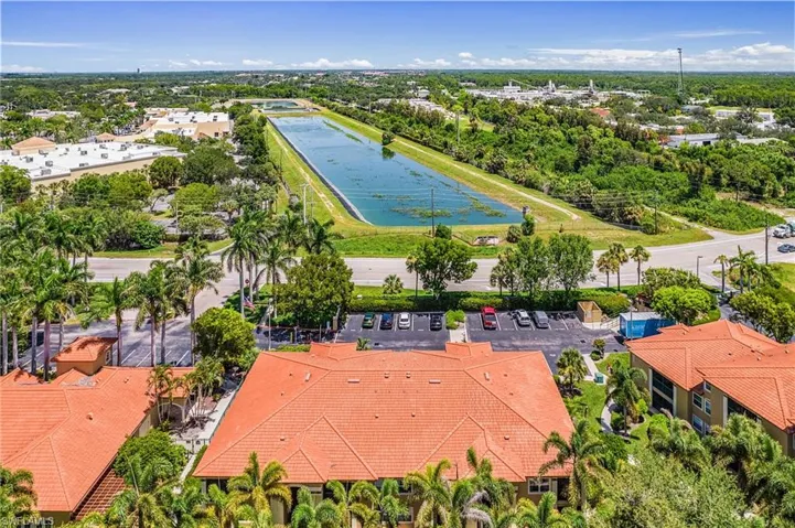 Aerial perspective featuring red tile roofs, multiple buildings, and a large water basin