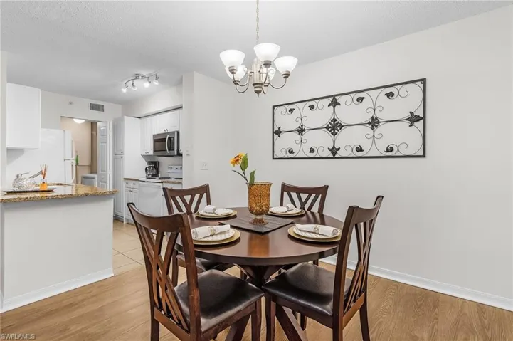 Kitchen with white cabinetry, stainless steel microwave, and a granite-style countertop