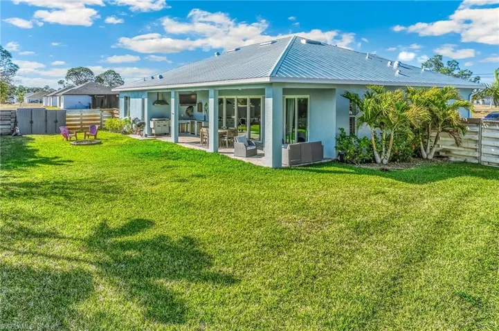 Back of property with a patio area, stucco siding, a metal roof, and outdoor furniture