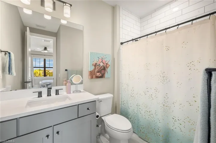 Ensuite bathroom featuring vanity, toilet, visible vents, a ceiling fan, and ensuite bathroom