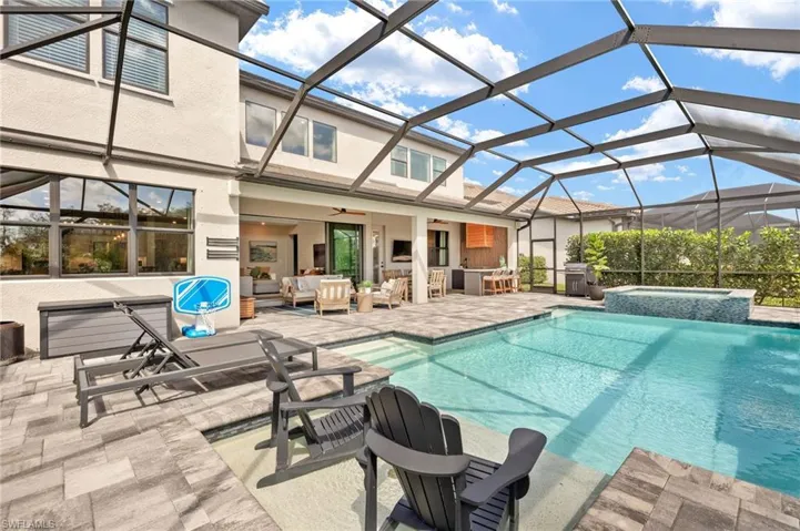 View of pool with ceiling fan, a pool with connected hot tub, area for grilling, outdoor lounge area, and a patio area