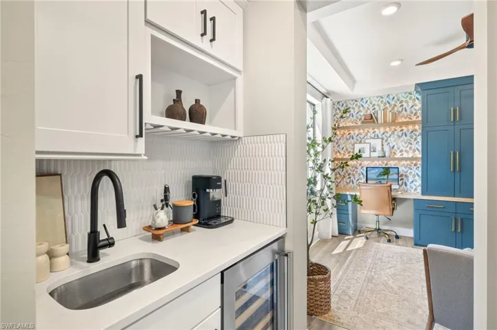 Kitchen featuring light countertops, a sink, open shelves, beverage cooler, and blue cabinets