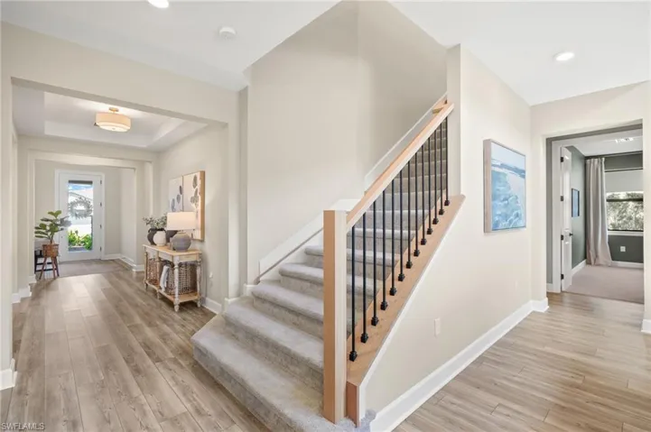 Entryway featuring light wood finished floors, stairs, and baseboards
